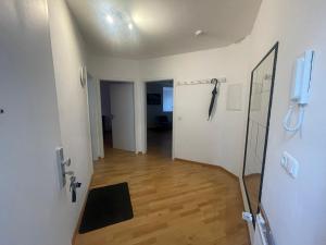 Zimmer mit einem Flur mit Tür und Holzboden in der Unterkunft Charmante 3-Zimmer-Wohnung Zentral in Wiesbaden in Wiesbaden