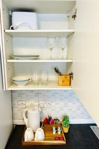 a cupboard with dishes and wine glasses on it at Private Studio Flat in City 1190 in London