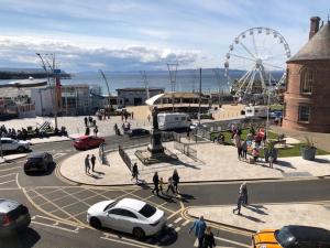 a city with a ferris wheel and people and cars at Beautiful Sea view, Entire 2 bed Apartment, Portrush centre West Strand BeachView in Portrush
