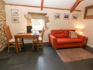 赫爾斯頓的住宿－Godolphin Barn，客厅配有红色的沙发和桌子