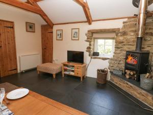 a living room with a fireplace and a tv at Godolphin Barn in Helston