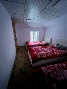 1 dormitorio con 2 camas y ventana en Bagu HOMESTAY 