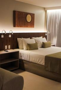 a bedroom with a large bed with a clock on the wall at Smart Hotel João Pessoa in João Pessoa