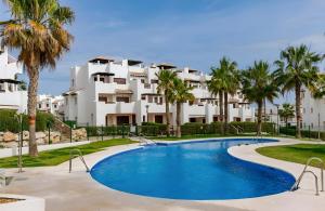 a resort with a swimming pool and palm trees at Hestía Vera Salinas Tu hogar para desconectar in Playas de Vera