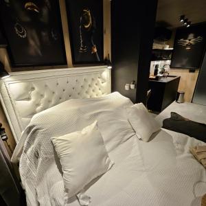 een bed met witte lakens en kussens in een kamer bij Glass House Pirita in Tallinn