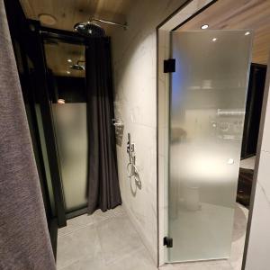 W łazience ze szklanymi drzwiami znajduje się przeszklona kabina prysznicowa. w obiekcie Glass House Pirita w Tallinnie