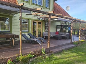 un patio con sofá y sillas en una terraza en Holidayhouse Tolsburg with sauna, en Toolse