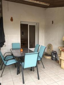 Un comedor con una mesa y sillas azules. en Agréable maison, en Pons