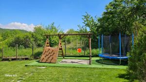 a playground with a slide and a swing at Вила Доброво in Dobrovo