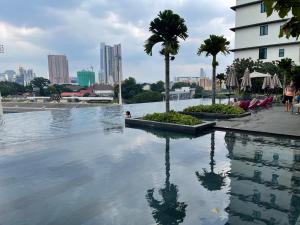 una piscina con vista sullo skyline della città sullo sfondo di Opus Residence Kuala Lumpur By Great Service a Kuala Lumpur