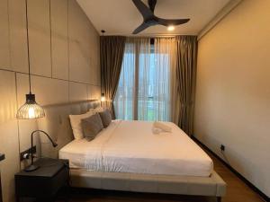 1 dormitorio con 1 cama blanca y ventilador de techo en Opus Residence Kuala Lumpur By Great Service, en Kuala Lumpur