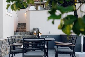 a table and chairs with wine glasses on a patio at Carpe Diem Suite in Liapades