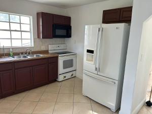 uma cozinha com um frigorífico branco e um lavatório em Private Rooms in West Palm Beach - Next to Airport em West Palm Beach