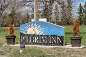 CaronportにあるPilgrim Innの2つの鉢植えが置かれたピルゼンの宿屋の看板