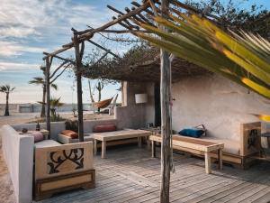 - une terrasse avec des canapés et des tables sur la plage dans l'établissement Surfiscamp Dakhla, à Dakhla