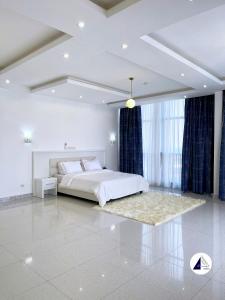 Dormitorio blanco con cama y ventana grande en Residence P en Kribi