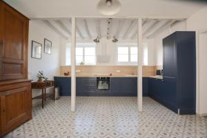 a large kitchen with blue cabinets and a counter at Le Petit Luquis - maison de campagne 7 chambres - in Chézy-sur-Marne +18 photos