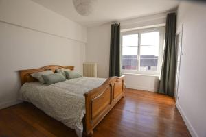 a bedroom with a bed and a large window at Le Petit Luquis - maison de campagne 7 chambres - in Chézy-sur-Marne