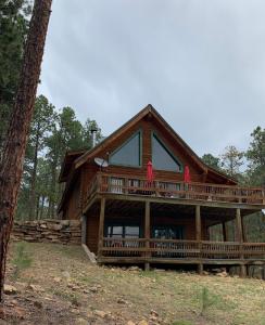 une grande maison en bois avec une grande terrasse dans l'établissement Bear Paw Lodge, à Vallecito