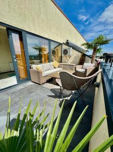 a patio with a couch and chairs on a balcony at PENTHOUSE EXCLUSIVE VIEW , Iasi in Iaşi