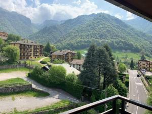 - un balcon offrant une vue sur une ville avec des montagnes dans l'établissement Appartamento nel cuore della Valsassina, à Moggio