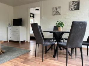 une salle à manger avec une table et des chaises noires dans l'établissement Boshuis Luyksgestel 2-6 personen, veel privacy!, à Luyksgestel