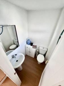 a bathroom with a sink and a toilet and a mirror at Chalet en Real de la Barrosa in Chiclana de la Frontera
