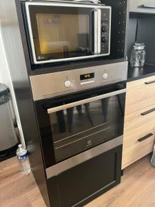 a microwave sitting on top of a black oven at Maison cosy en plein centre ville in Semur-en-Auxois