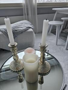 uma mesa de vidro com duas velas e um suporte para velas em Kaupunkikoti erinomaisella sijainnilla em Porvoo