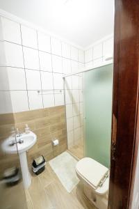 a bathroom with a toilet and a sink at Pousada no coração de Londrina in Londrina