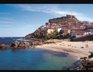 a group of people on a beach with a mountain at Affittacamere Dal Duca Enrico in Castelsardo