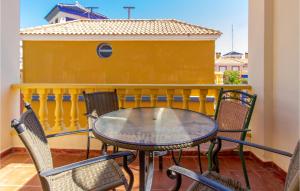 d'une table et de chaises sur un balcon avec un mur jaune. dans l'établissement Amazing Apartment In Torrevieja With Kitchen, à Torrevieja