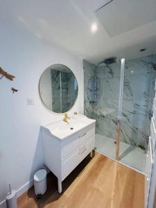ein Badezimmer mit einem weißen Waschbecken und einer Dusche in der Unterkunft La petite maison in Loeuilly
