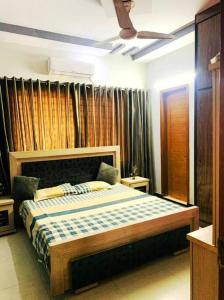 ein Schlafzimmer mit einem Bett in einem Zimmer mit Vorhängen in der Unterkunft Sunrise Family Stay Gulshan Nipa in Karatschi