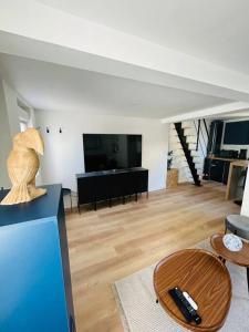 ein Wohnzimmer mit einem Sofa und einem Tisch in der Unterkunft La petite maison in Loeuilly