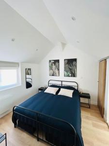 ein Schlafzimmer mit einem blauen Bett in einem weißen Zimmer in der Unterkunft La petite maison in Loeuilly