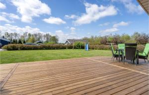 a wooden deck with chairs and a table on it at Holiday Home Strandparken Xi in Otterup +15 photos