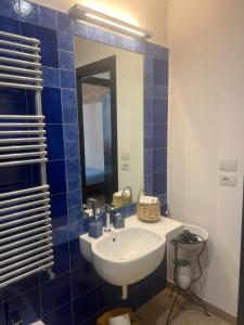 a blue tiled bathroom with a sink and a mirror at Alle volte… in Bisceglie +11 photos
