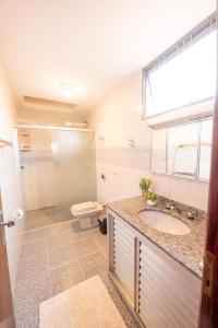 a bathroom with a sink and a toilet at Pousada no coração de Londrina in Londrina