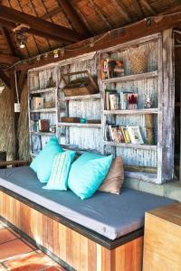 a bed with pillows on it in a book shelf at The Beach House in Kep