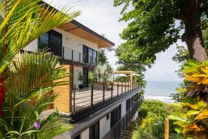 a house with a balcony overlooking the ocean at Villa Nof Yam in Santa Teresa Beach