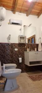 bagno con servizi igienici bianchi e lavandino di La casa dei kiwi a Lanuvio