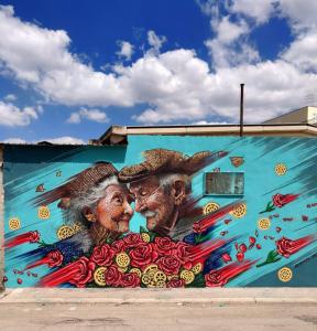 a mural of two people on the side of a building at Asturnara Apartment in Stornara