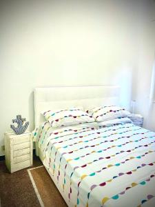 a bedroom with a white bed with a colorful comforter at Casa Aysha in Bogliasco