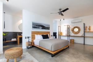 ein weißes Schlafzimmer mit einem Bett und einem Stuhl in der Unterkunft Villa Nof Yam in Playa Santa Teresa