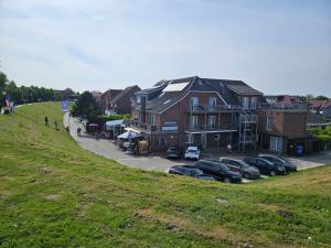 eine Gruppe von Häusern auf einem Hügel mit geparkten Autos in der Unterkunft NordseeResort Hotel & Suite Arche Noah in Horumersiel