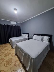 two beds in a room with blue walls at Villa Fátima Hostel GRU in Guarulhos