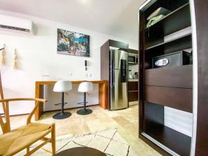 cocina con nevera y 2 sillas en una habitación en Modern Studio Downtown with Rooftop, Pool, Gym and Parking, en Tulum