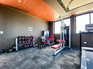 Un gimnasio con dos sillas y equipos en una habitación. en Modern Studio Downtown with Rooftop, Pool, Gym and Parking, en Tulum