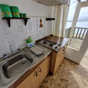 a kitchen with a sink and a stove at Max & Mar Pichilemu in Pichilemu